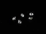 four diamonds on a black surface with a black background