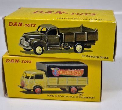 two boxes of dan - toy trucks sitting on top of each other