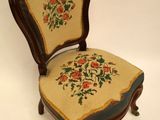 an old chair with a floral design on the back of it