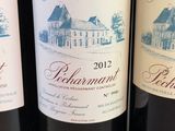 three bottles of red wine are lined up on a table