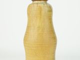a yellow vase that is sitting on a white surface