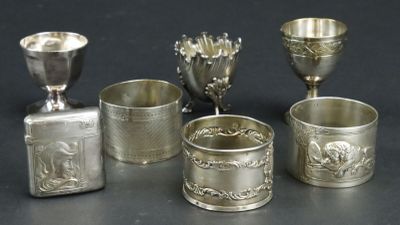 five silver cups and a silver vase on a table
