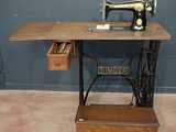 une vieille machine à coudre posée sur une table dans une pièce