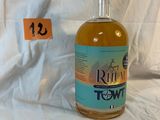 a bottle of rum that is sitting on a bed
