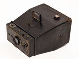 an old camera that is sitting on a white surface