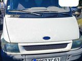 une camionnette blanche garée sur un parking, avec le numéro 13 sur le devant