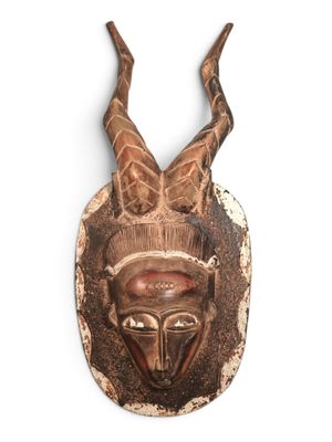 une image représentant un masque en bois muni de cornes sur fond blanc