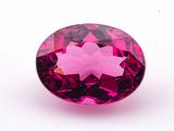 a close up of a pink diamond on a white surface