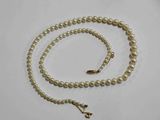 gros plan d'un collier de perles sur une surface blanche