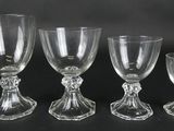four glass goblets and a wine glass on a black background