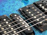 a close up of a blue electric guitar with a lot of strings