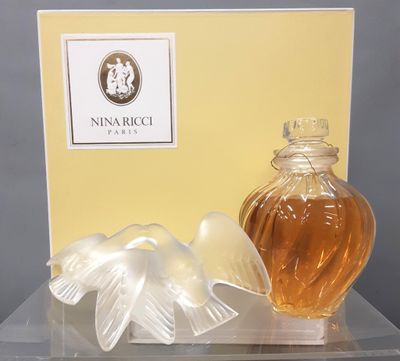 a bottle of perfume next to a box on a table