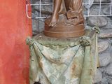 une statue représentant un homme tenant un chien sur un socle