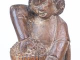 wooden statue of a child holding a basket of fruit