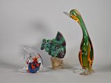 trois figurines en verre de formes et de tailles différentes posées sur une table