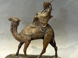 bronze statue of a woman riding a camel with a spear in her hand