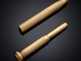 un stylo doré et un briquet sur fond noir