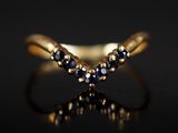 gros plan d'une bague en or avec des saphirs bleus