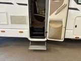a white rv parked in a garage with its door open