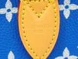 a close up of a louis vuitton bag on a blue surface