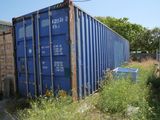 a blue shipping container sitting on the side of the road