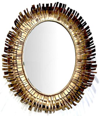 un miroir doré orné d'un motif en rayons de soleil