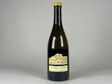 une bouteille de vin posée sur une table blanche