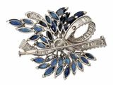 silver and blue broochle with a bow and a key on it