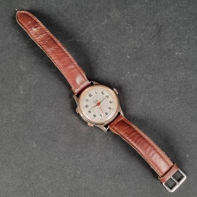 an image of a watch with a brown leather strap on a table
