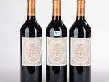 trois bouteilles de vin posées sur une table blanche