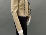 a mannequin mannequin wearing a beige jacket and black pants
