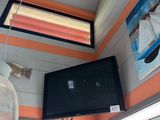 a flat screen tv hanging from the ceiling in a small room