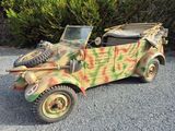 an old military vehicle that is parked in the gravel