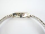 a close up of a silver bracelet on a white surface