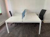 a white desk with a black chair and a computer monitor on it