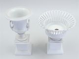 pair of white vases with handles on pedestals on white background