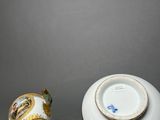 two white and gold vases with a gold decoration on them