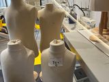 several mannequins are lined up on a table in a factory