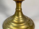 a gold candle that is sitting on a white table