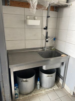 une cuisine avec un évier et deux seaux à l'intérieur