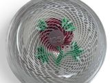 an overhead view of a glass bowl with a red flower on it