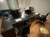 a desk with two computers and a chair in a room