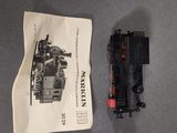 a small toy train on the table next to a bag