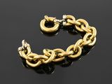 a close up of a gold chain bracelet on a black surface