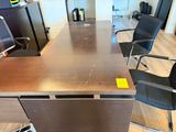 a long table with chairs and a laptop on it
