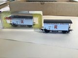 two toy train cars sitting on a table next to a box
