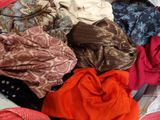a pile of clothes sitting on top of a bed