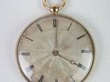une montre de poche en or avec des chiffres romains sur le cadran