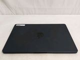 a black apple laptop sitting on a white surface