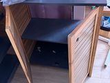 a desk with a black top and a wooden cabinet